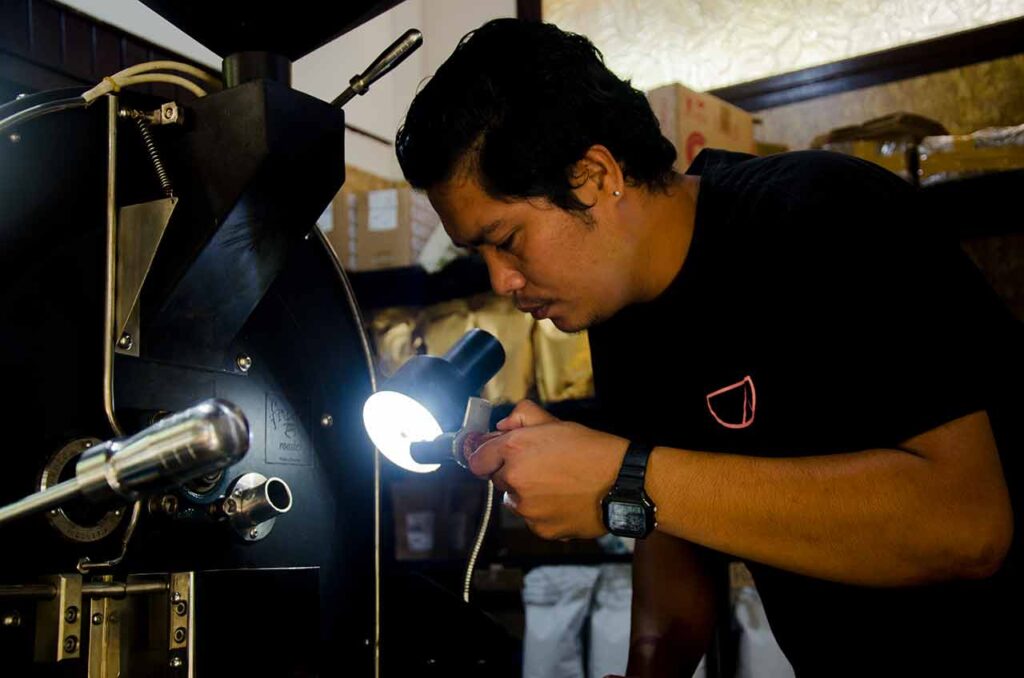 Gus Adi, a coffee roaster is checking roasted beans. Photo: Pourmorecoffee.com
