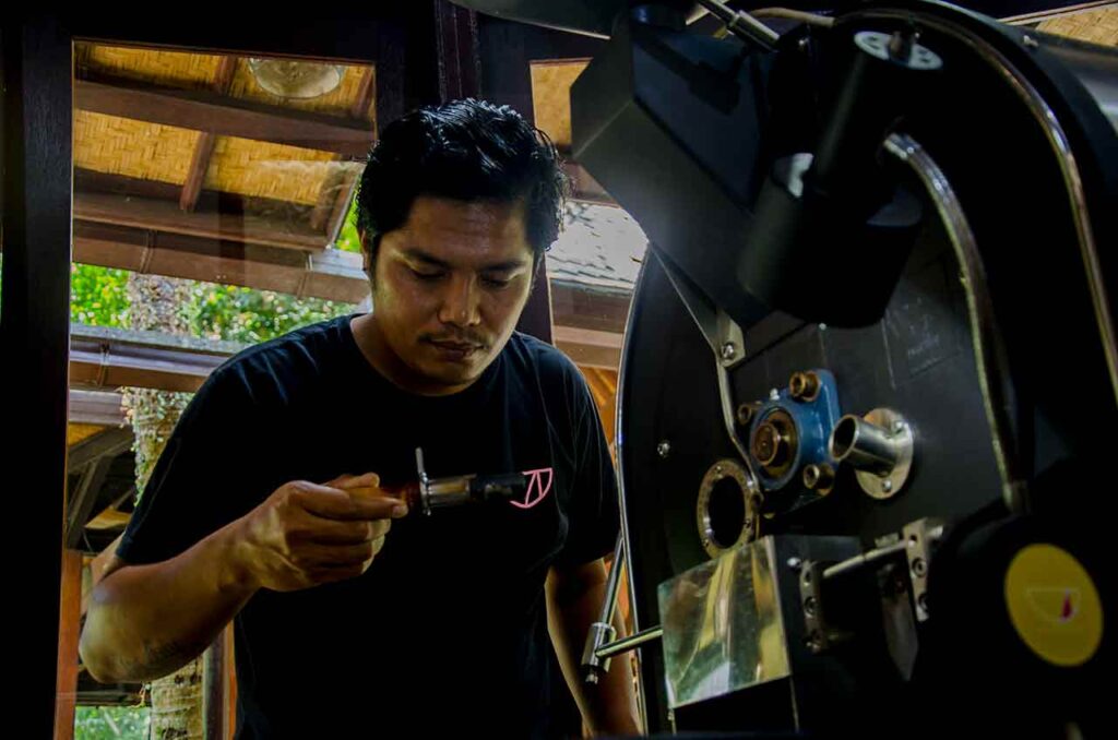 Gus Adi Kopi, a coffee roaster is checking the roasted beans color. Photo: Pourmorecoffee.com