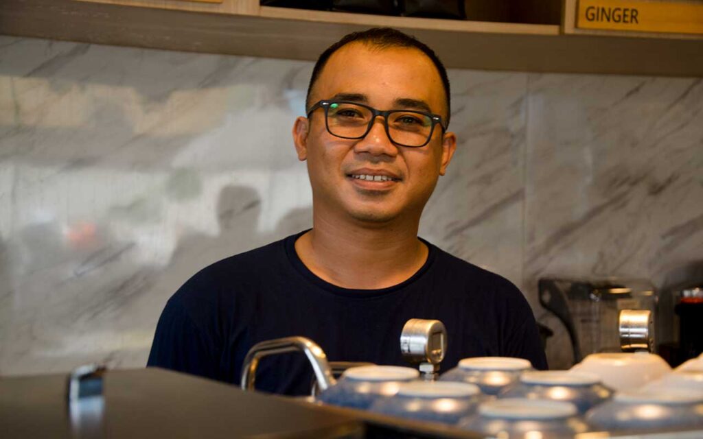 Bli Dika barista Iraga Coffee behind coffee bar. Photo: pourmorecoffee.com