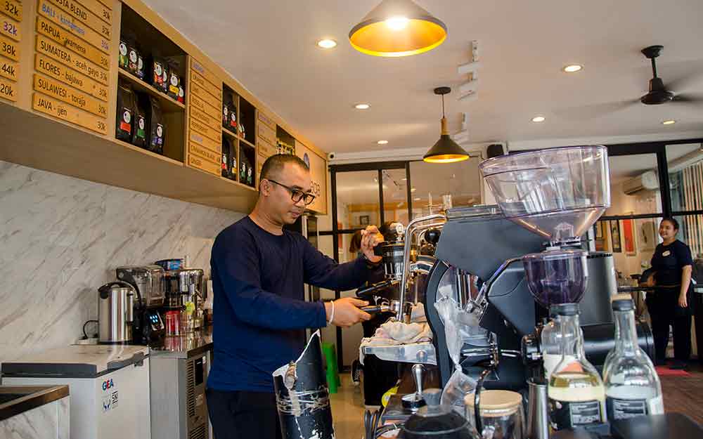 Bli Dika Meidika barista Iraga Coffee behind espresso machine. Photo: pourmorecoffee.com