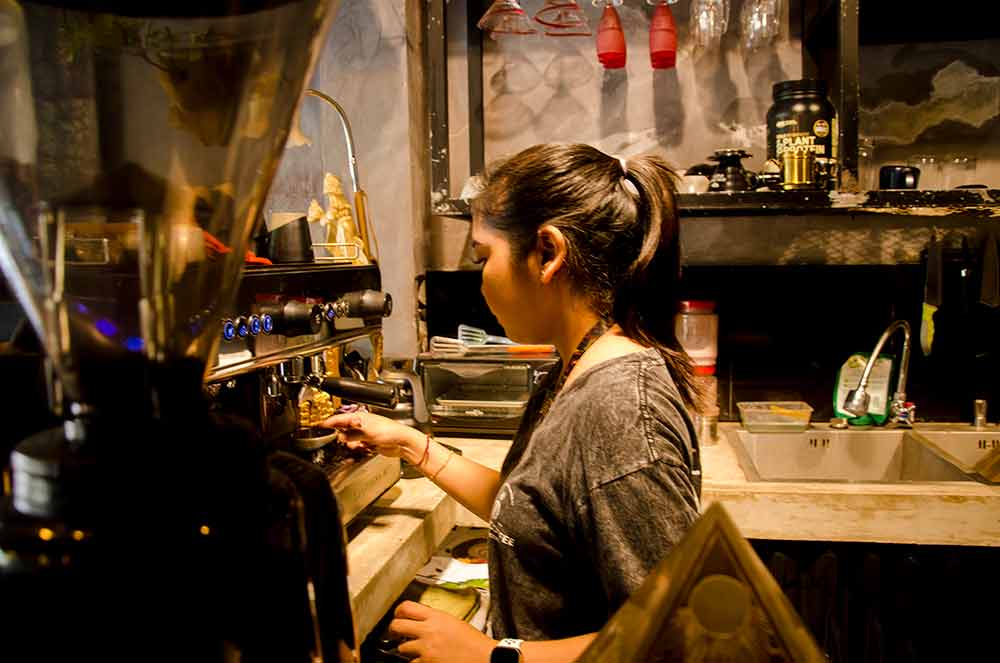 Putri Wahyuni Ubud Barista is waiting for espresso coffee extraction - Putri Wahyuni Barista Perempuan Ubud. Photo: pourmorecoffee.com