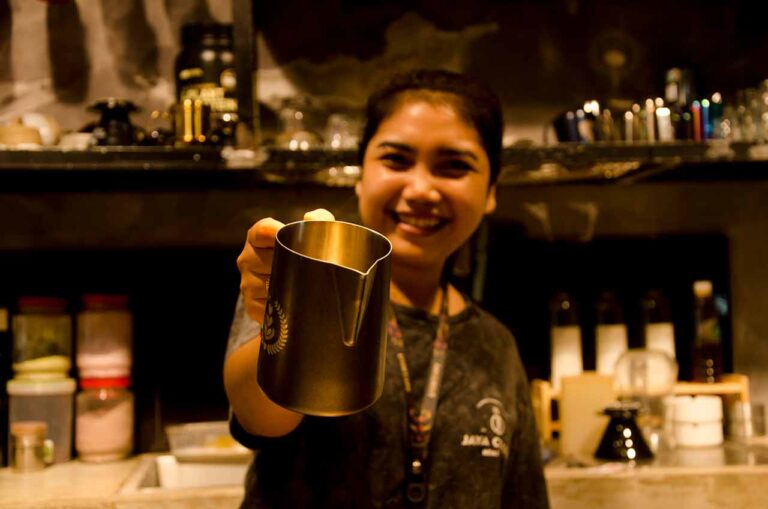 Putri Wahyuni Ubud Female Barista is showing a milk jug - Putri Barista Perempuan Ubud. Photo: pourmorecoffee.com