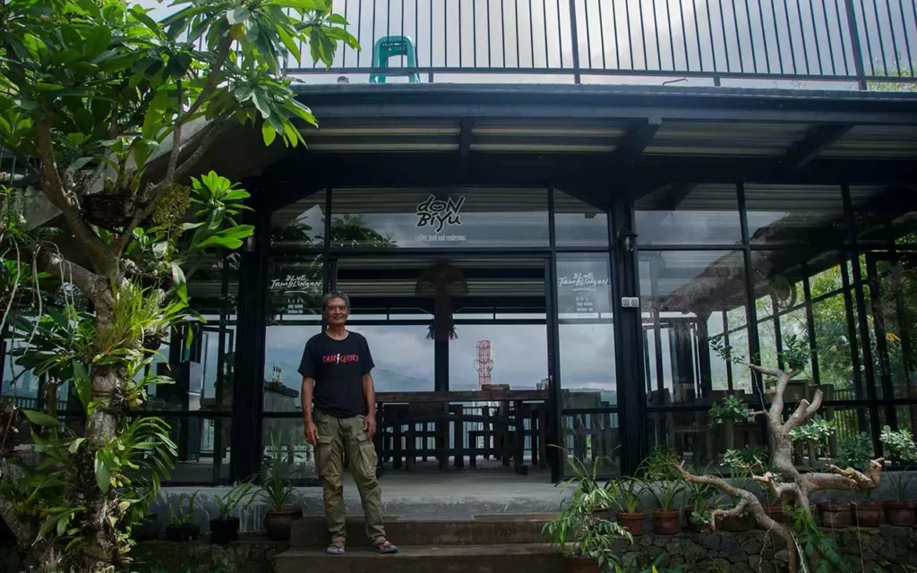 Putu Ardana is in front of his coffee shop. Pelestari lingkungan Munduk berdiri di depan Don Biyu, kedai kopi yang terhenti karena pandemi covid-19. Photo: pourmorecoffee.com