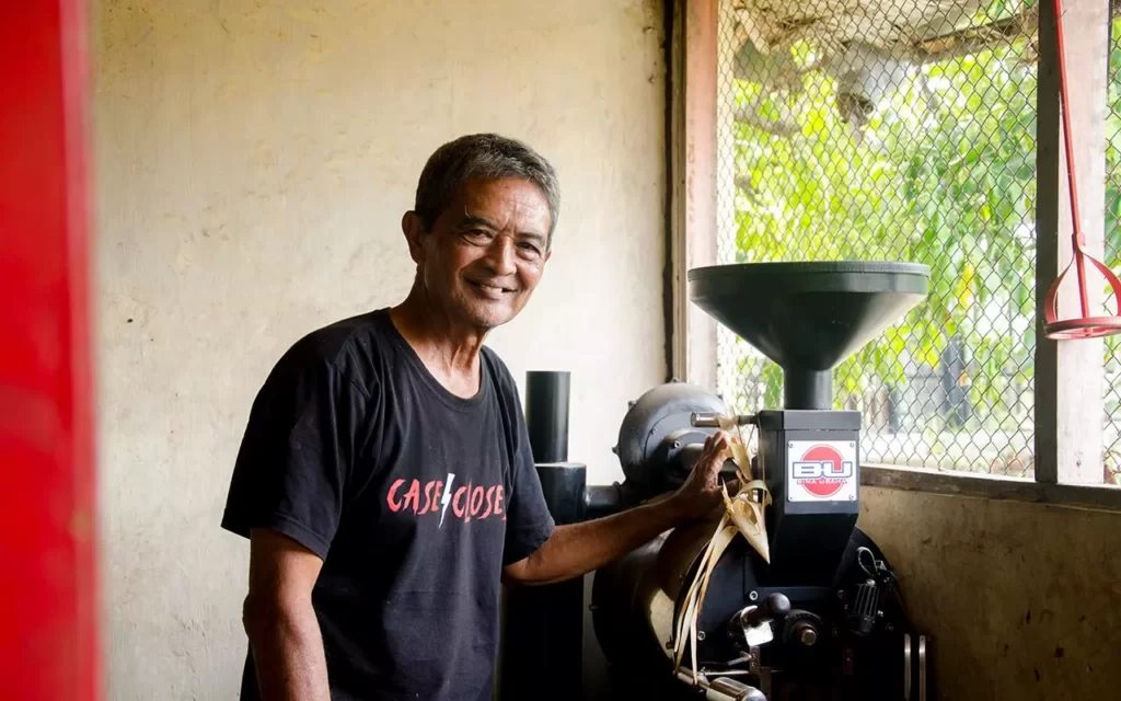 Putur Ardana with his coffee roasting machine. Pemilik brand Blue Tamblingan di samping mesin sangrainya. Photo: pourmorecoffe.com