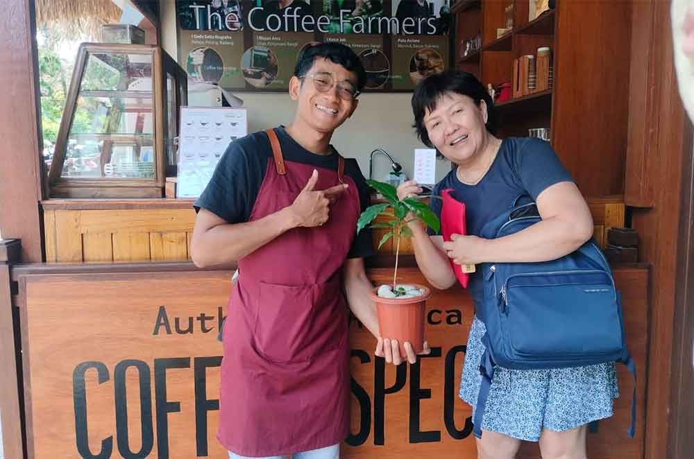 Ainah contributes coffee seedling to Bali coffee farmer. Photo: Pourmore Coffee